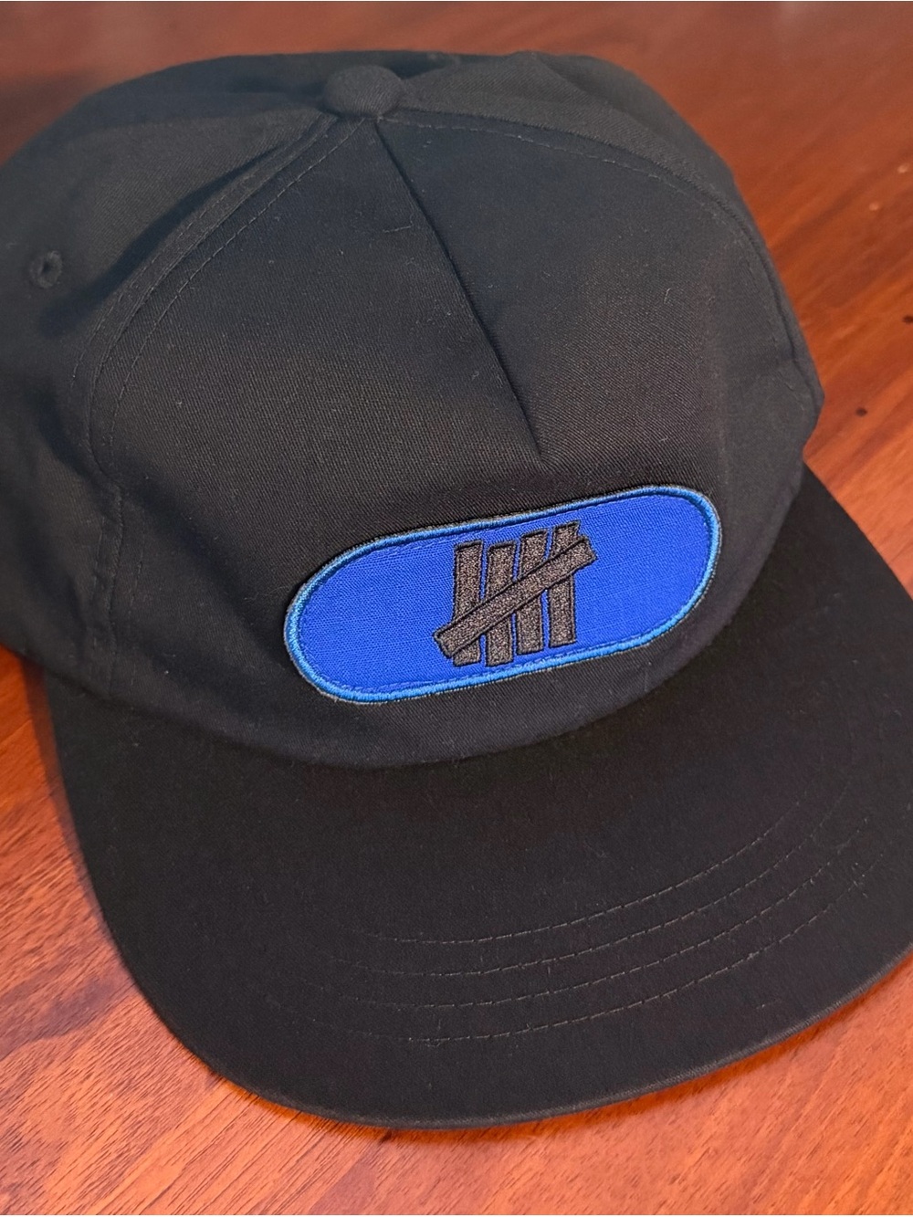 Undefeated Black Snapback with Blue Patch and Black Embroidered Logo